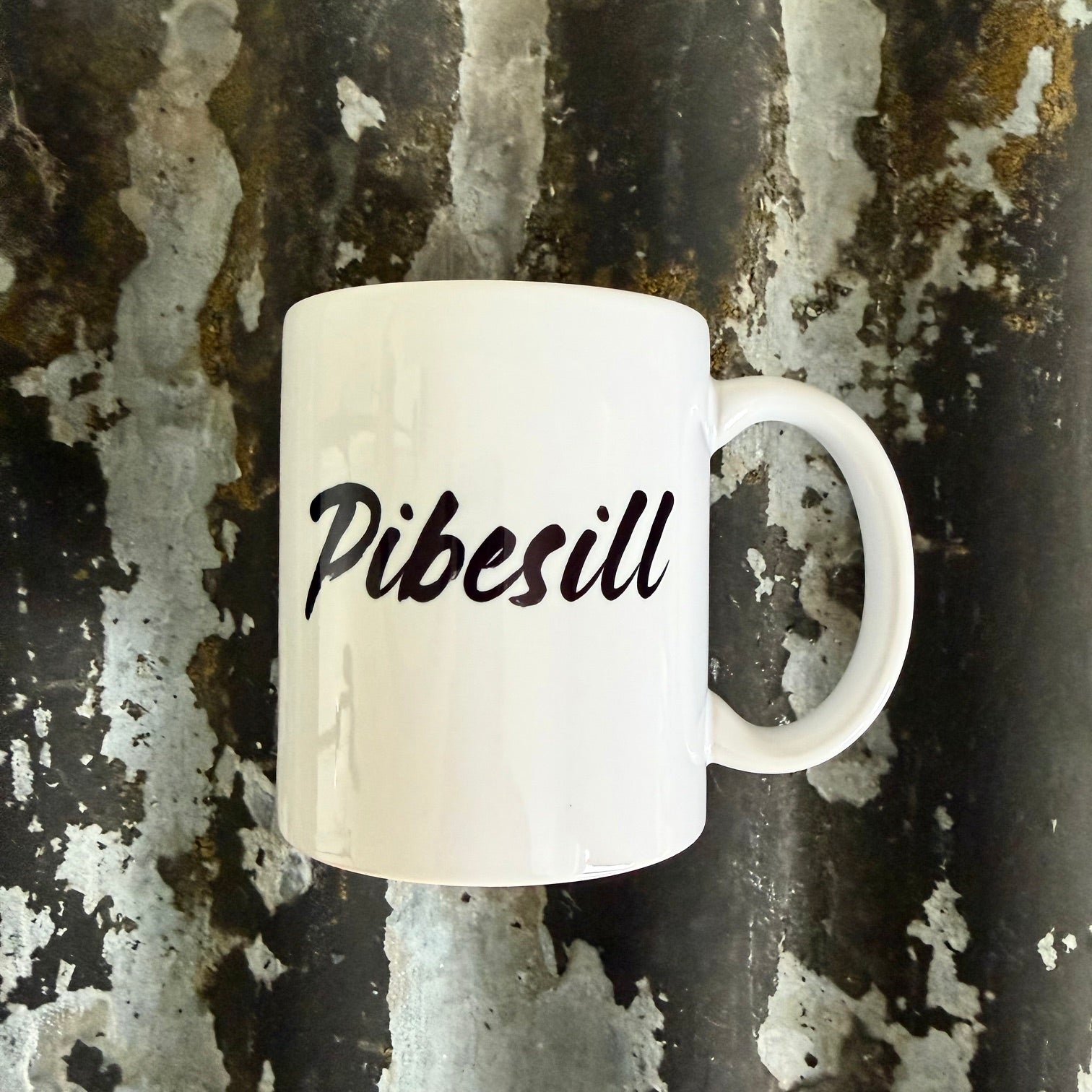 Nyssa Pibesill mug with colorful, playful design on white ceramic, ideal for hot beverages and everyday use.