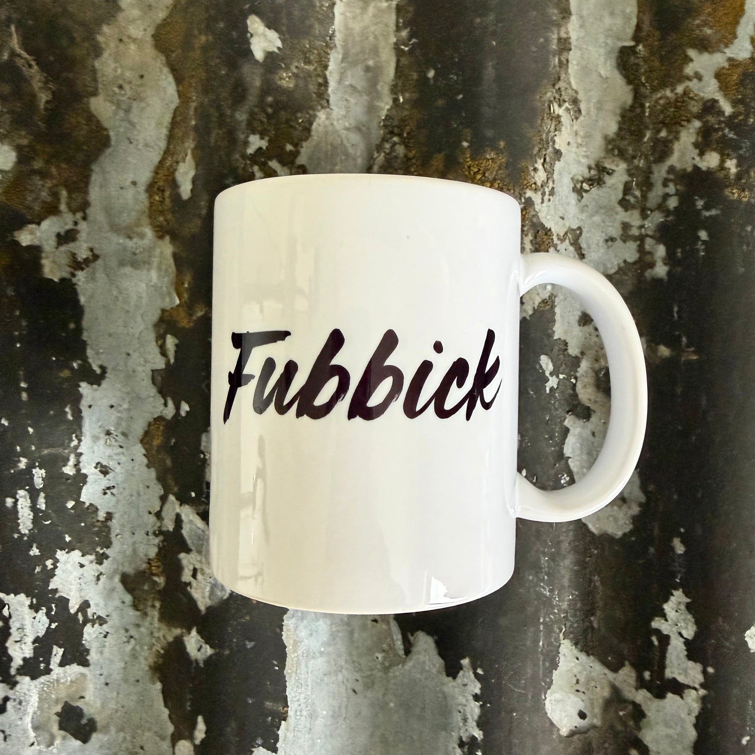 Nyssa Fubbick mug with colorful, playful design featuring abstract patterns and vibrant hues on a white ceramic surface.