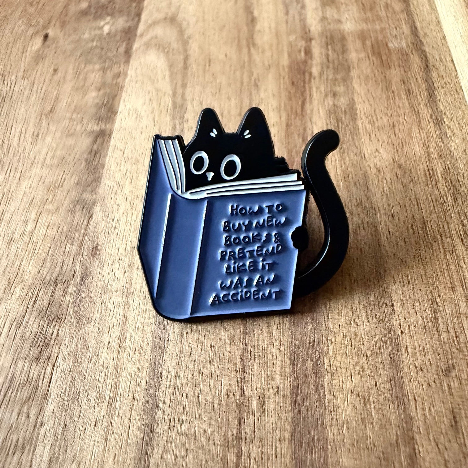 Nyssa pin featuring "How to buy new books" design, a collectible enamel pin with detailed artwork and vibrant colors.