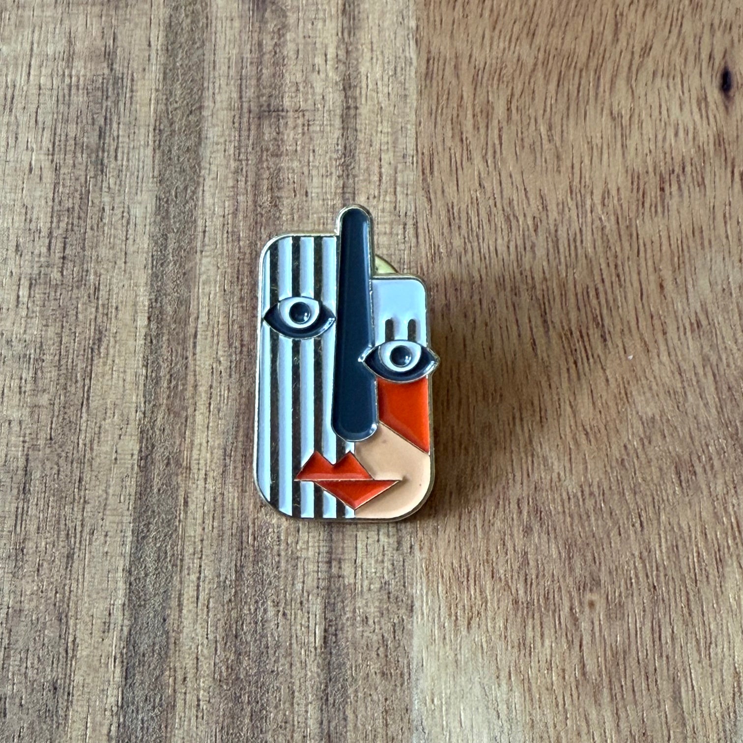 Nyssa Art2 pin featuring a colorful, artistic design with a metallic finish, displayed on a neutral background.