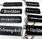 Black acrylic keyring with custom engraved text from Nyssa, featuring a sleek and modern design.