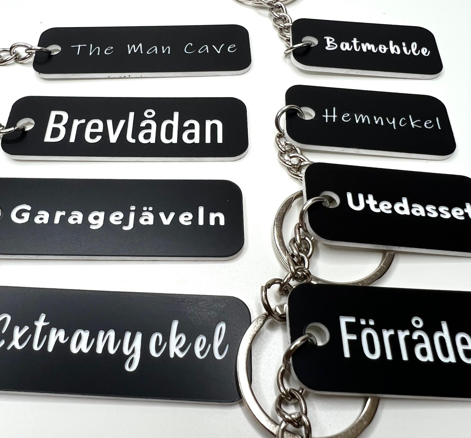 Black acrylic keyring with custom engraved text from Nyssa, featuring a sleek and modern design.