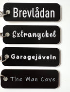 Black acrylic laminated keyring with custom engraved text from Nyssa, featuring a sleek and modern design.