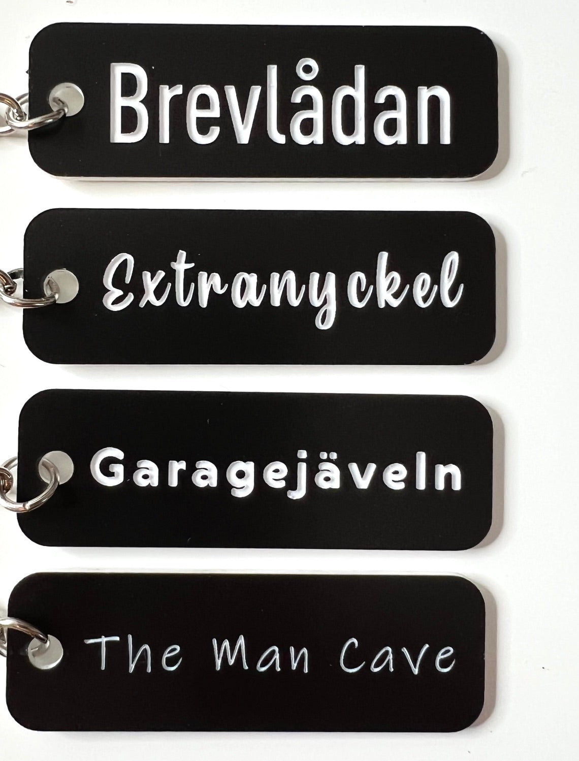 Black acrylic laminated keyring with custom engraved text from Nyssa, featuring a sleek and modern design.