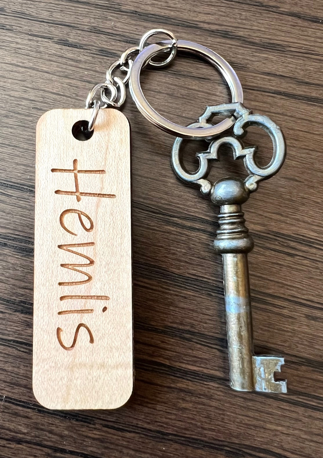 Nyssa custom wooden keychain with engraved personal text, made from wood laminate, displayed on a neutral background.