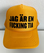 Nyssa trucker keps with bold printed slogan "JAG ÄR EN F**KING TIA" on the front, adjustable mesh back and structured design.