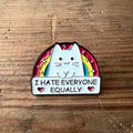 Nyssa "I hate everyone equally" pin showing a metal badge with bold black text on a white background.