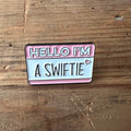 Nyssa "Hello I’m a Swiftie" pin featuring a colorful design, perfect for fans of Taylor Swift to wear on clothing or accessories.