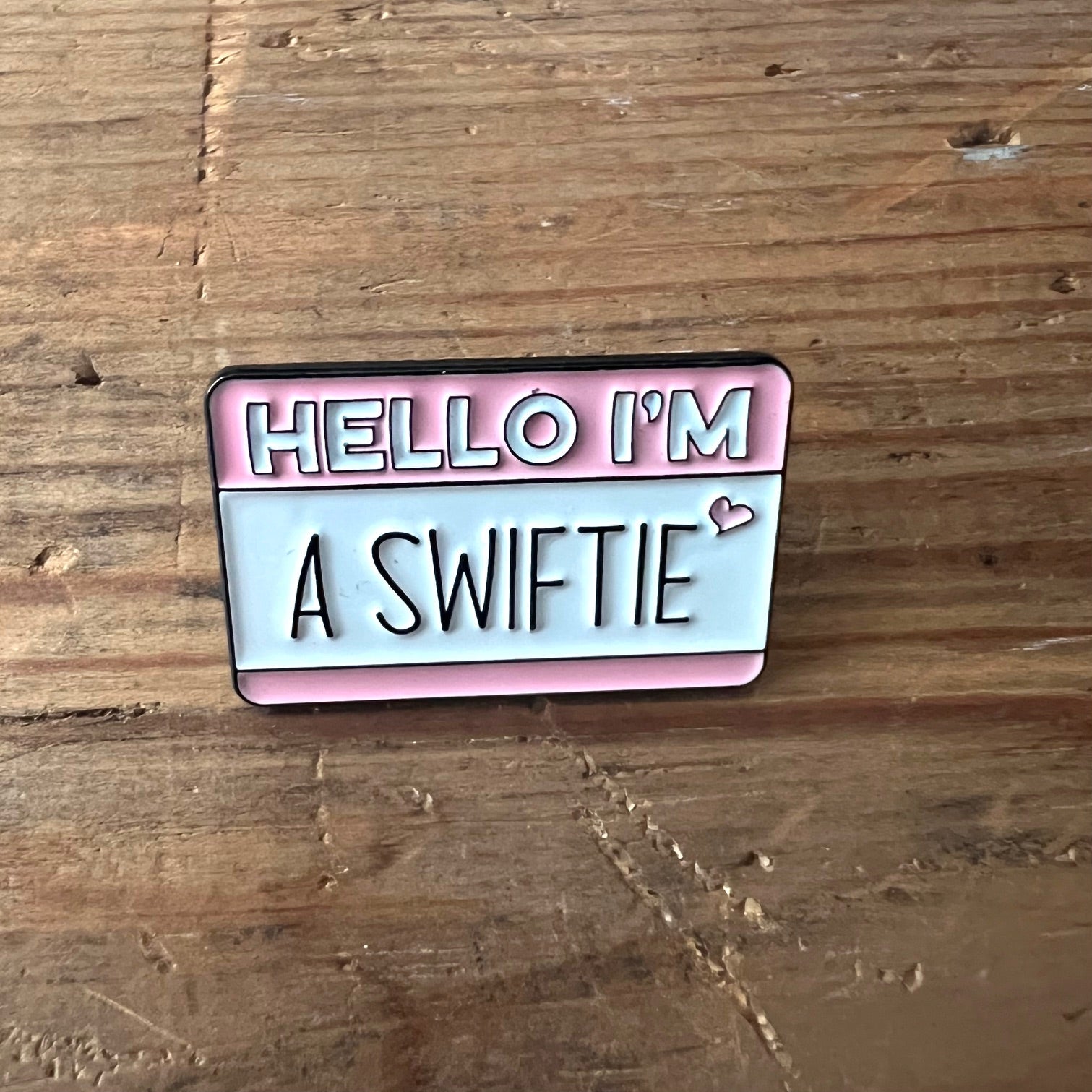 Nyssa "Hello I’m a Swiftie" pin featuring a colorful design, perfect for fans of Taylor Swift to wear on clothing or accessories.