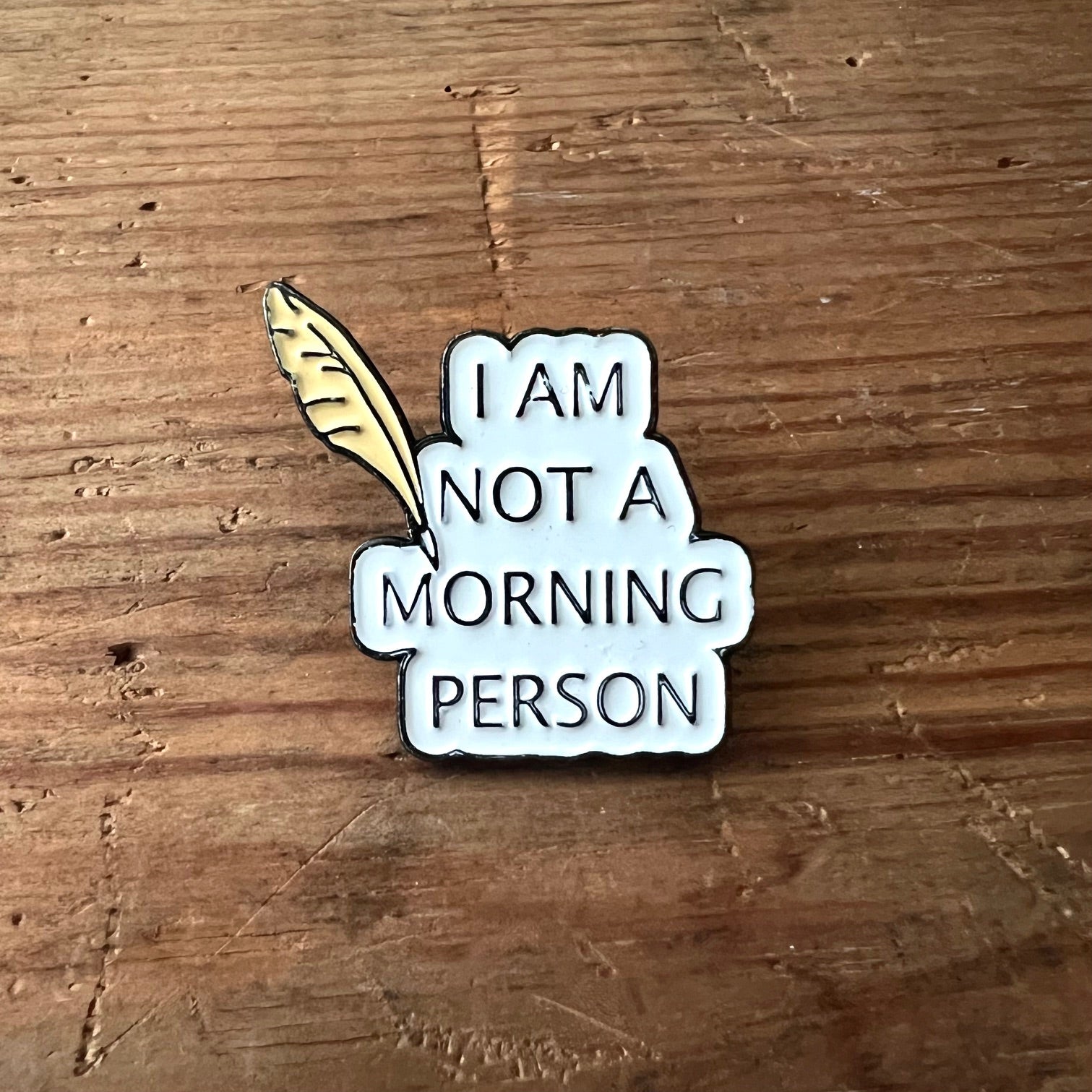 Nyssa "I'm Not a Morning Person" pin showing a colorful enamel pin with bold text on a white background.
