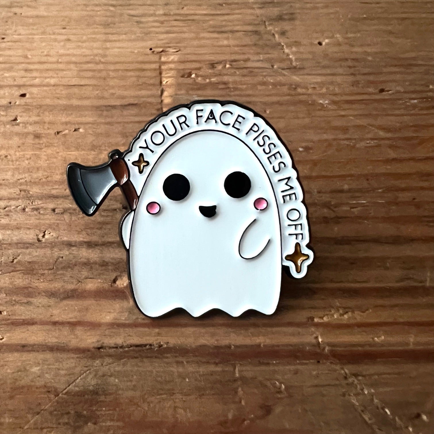 Nyssa "Your face pisses me off" pin showing a humorous face design on a metal lapel pin.