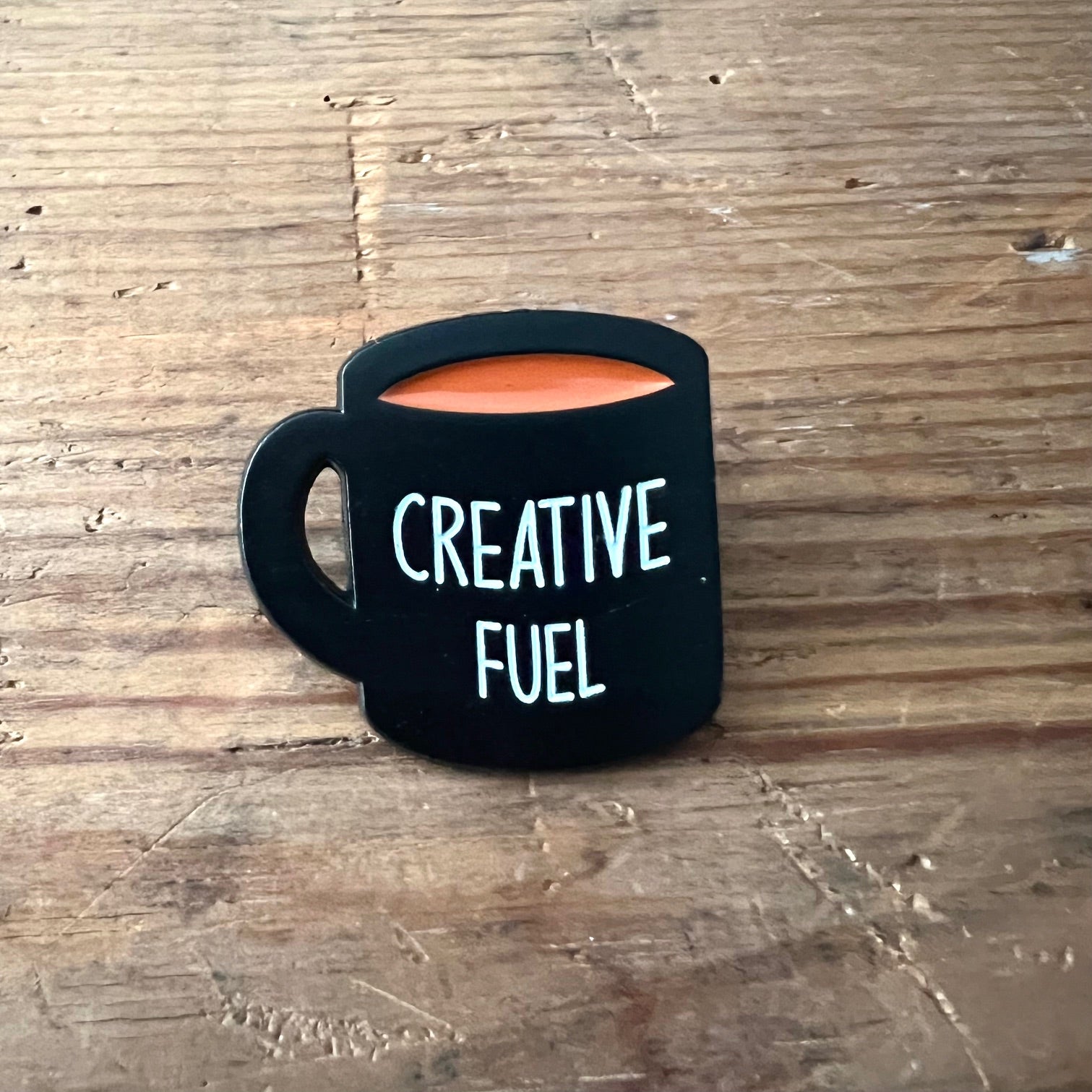 Nyssa Creative Fuel pin featuring vibrant colors and intricate design, perfect for accessorizing bags or clothing.