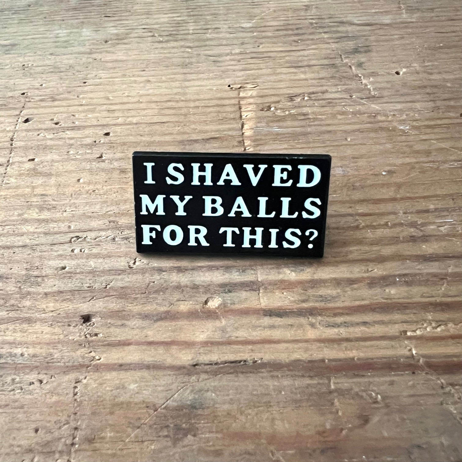 Nyssa "I shaved my balls for this?" pin featuring bold text on a metal lapel pin, perfect for humorous accessories.