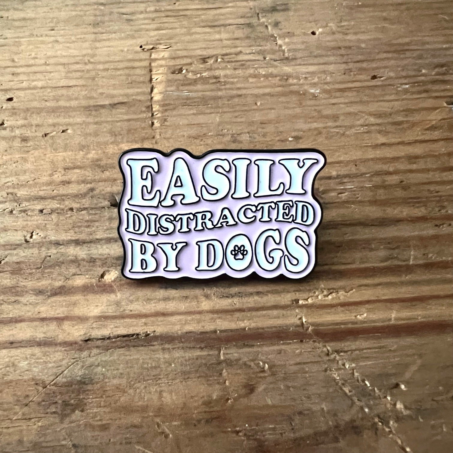 Easily distracted by dogs pin by Nyssa, featuring a playful design perfect for dog lovers on clothing or accessories.