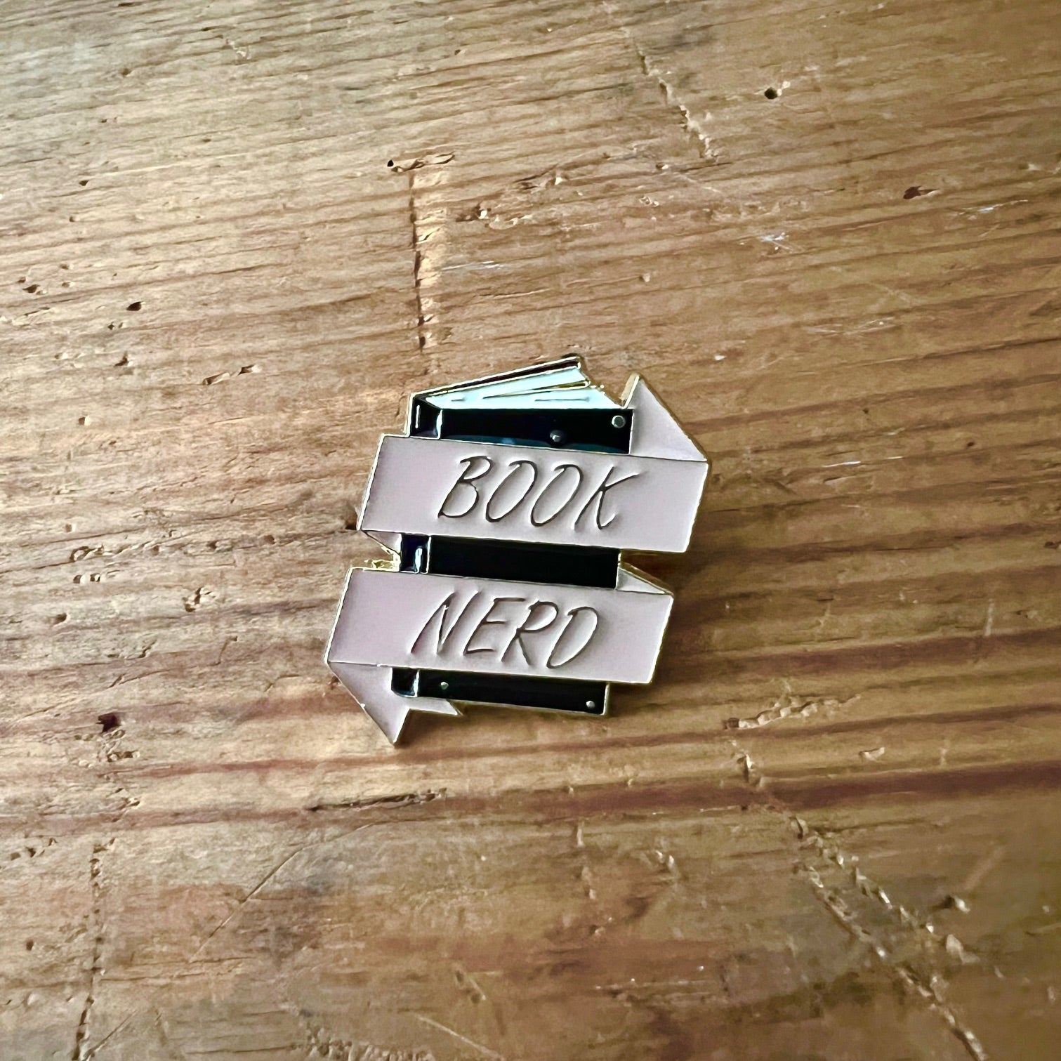 Nyssa Book Nerd pin featuring a colorful literary-themed design, perfect for book lovers and pin collectors.