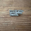Nyssa "Sorry I’m late. I didn’t want to come" pin, metal badge with humorous message, featuring a safety pin backing.