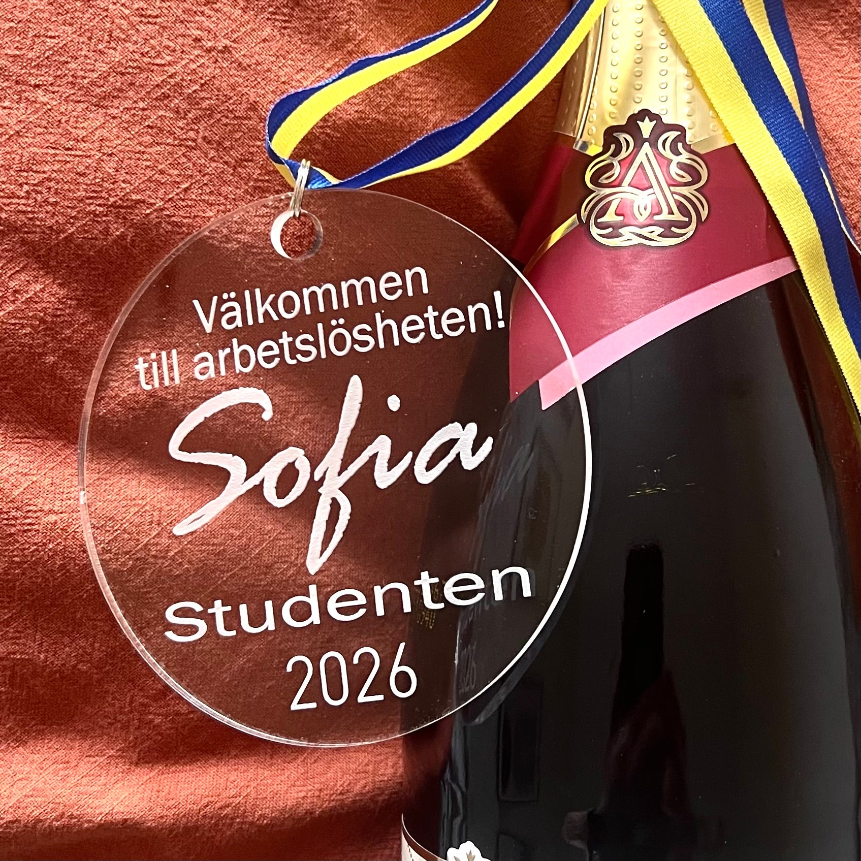Nyssa Studenthänge with "Arbetslös" design, showcasing a stylish student accessory with bold lettering on a neutral background.