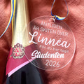 Nyssa studenthänge "Skiten är över" with humorous design, hanging on a display, perfect for celebrating graduation.