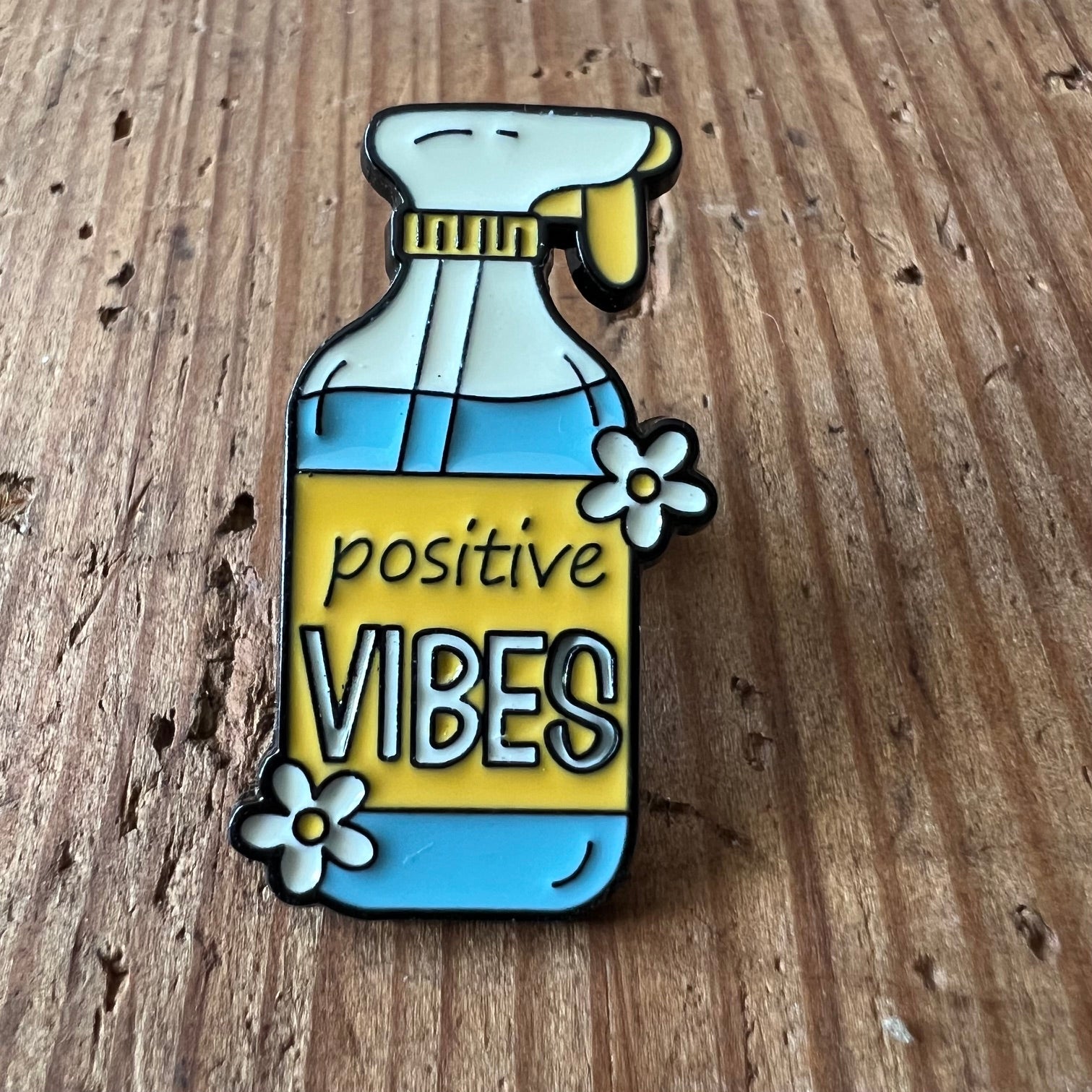 Yellow "Positive Vibes" pin by Nyssa featuring a cheerful design, perfect for accessorizing bags or clothing.
