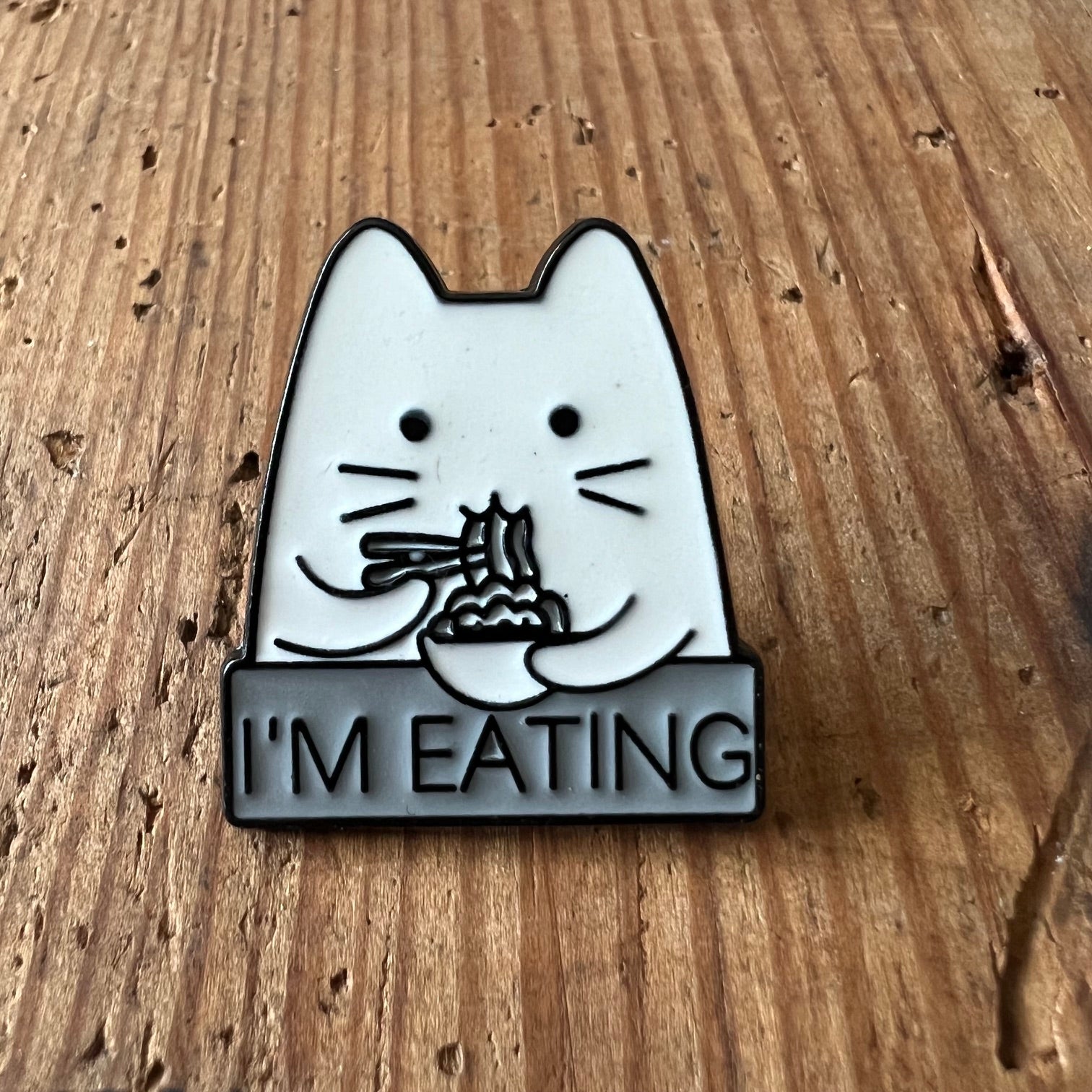 Nyssa "I'm Eating" enamel pin showing a playful design, perfect for accessories or clothing embellishments.