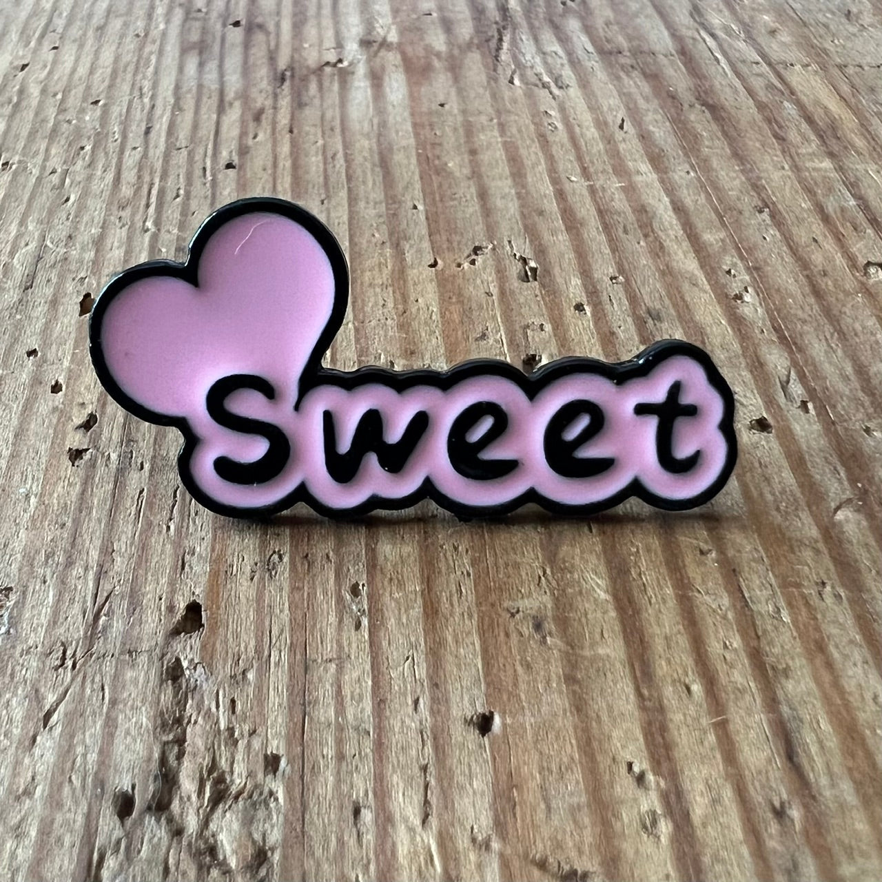 Nyssa Sweet pin featuring a colorful, decorative design on a metal pin for accessorizing or collection.