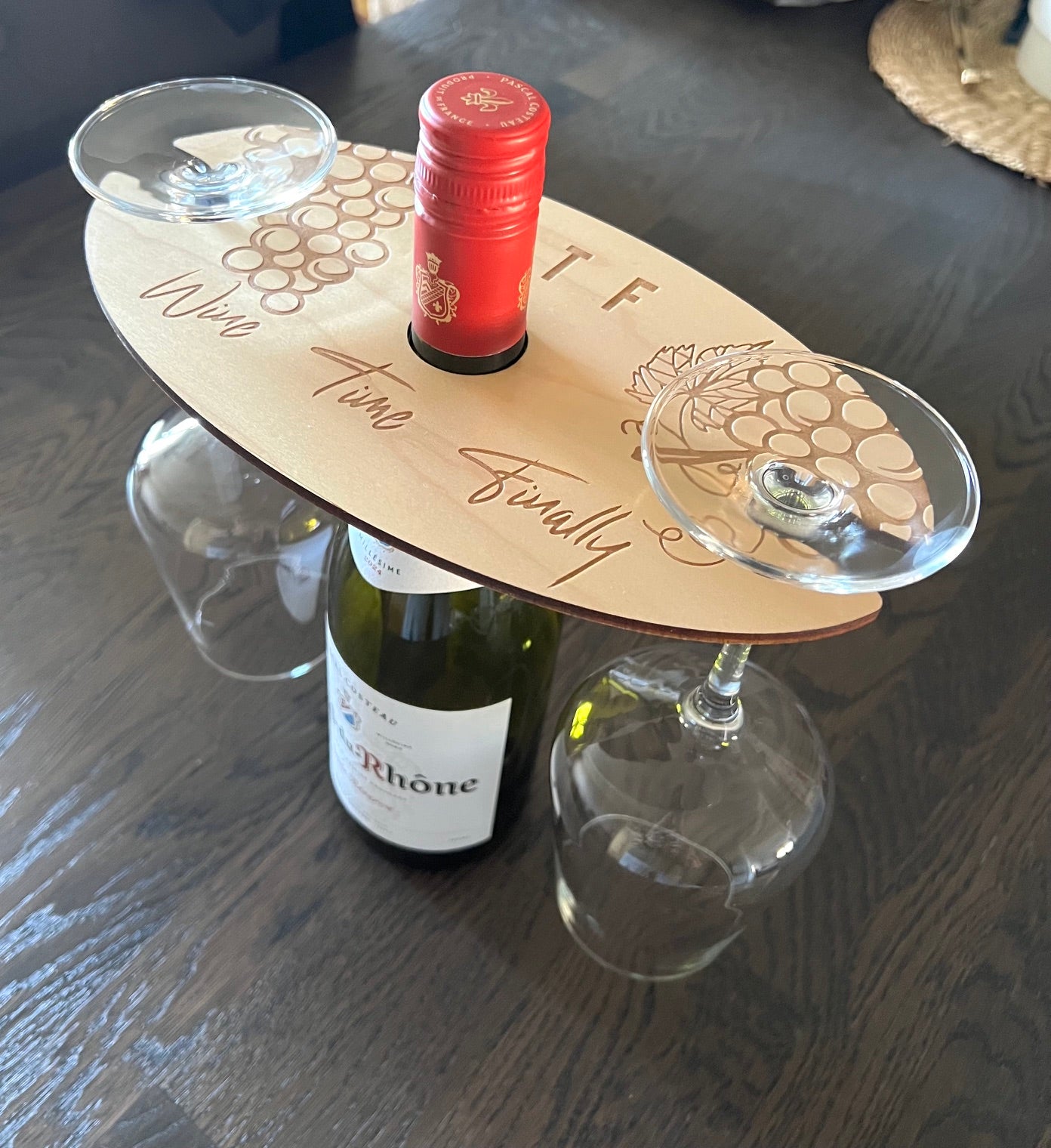 Nyssa glass holder for bottles, stylish and functional, shown holding a bottle in a modern kitchen setting.