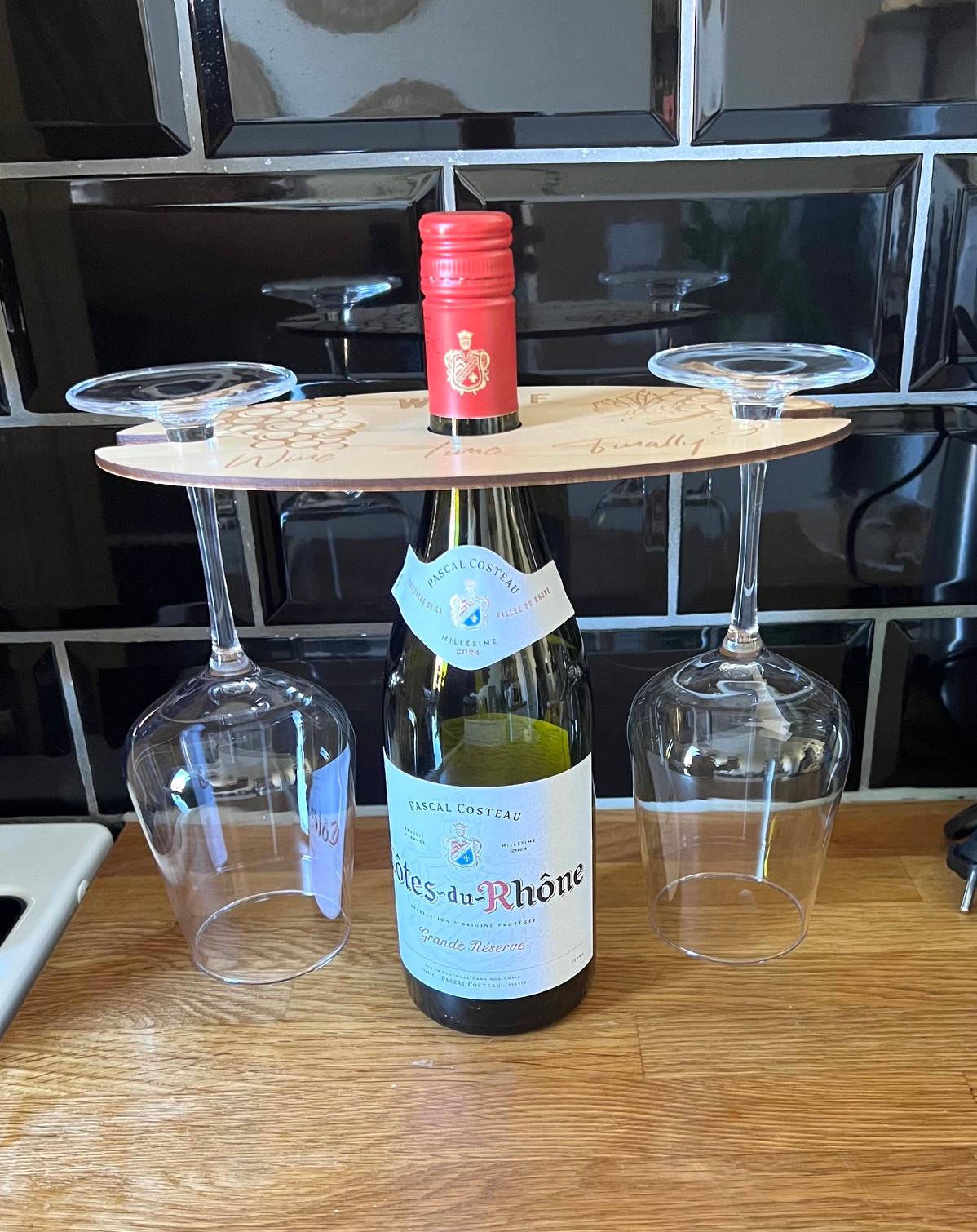 Nyssa glass holder for bottles, sturdy and practical, shown mounted on a surface with the bottle securely held in place.