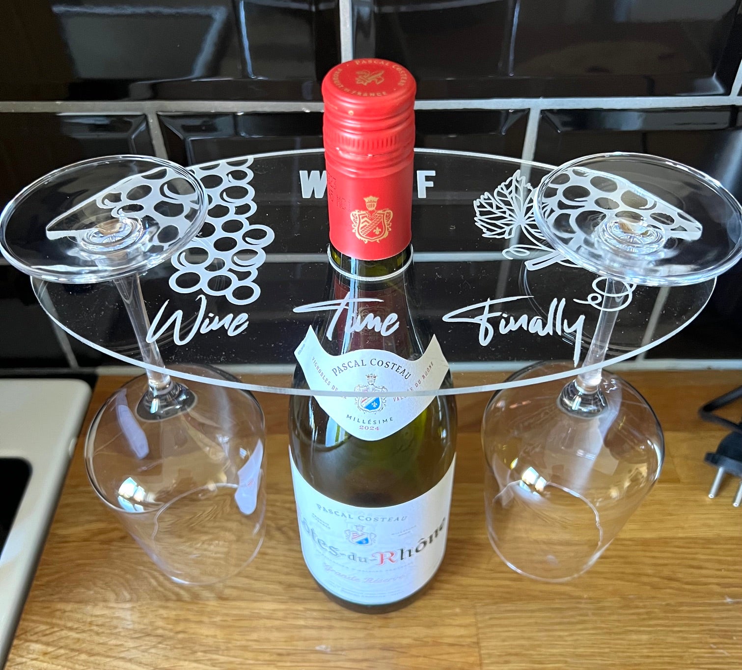 Nyssa glass holder for bottles, black metal design, securely holds glasses in place, ideal for bar or kitchen use.