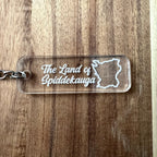 Nyssa Skåne keyring featuring a detailed design of the land of Spiddekauga on a metal keychain.