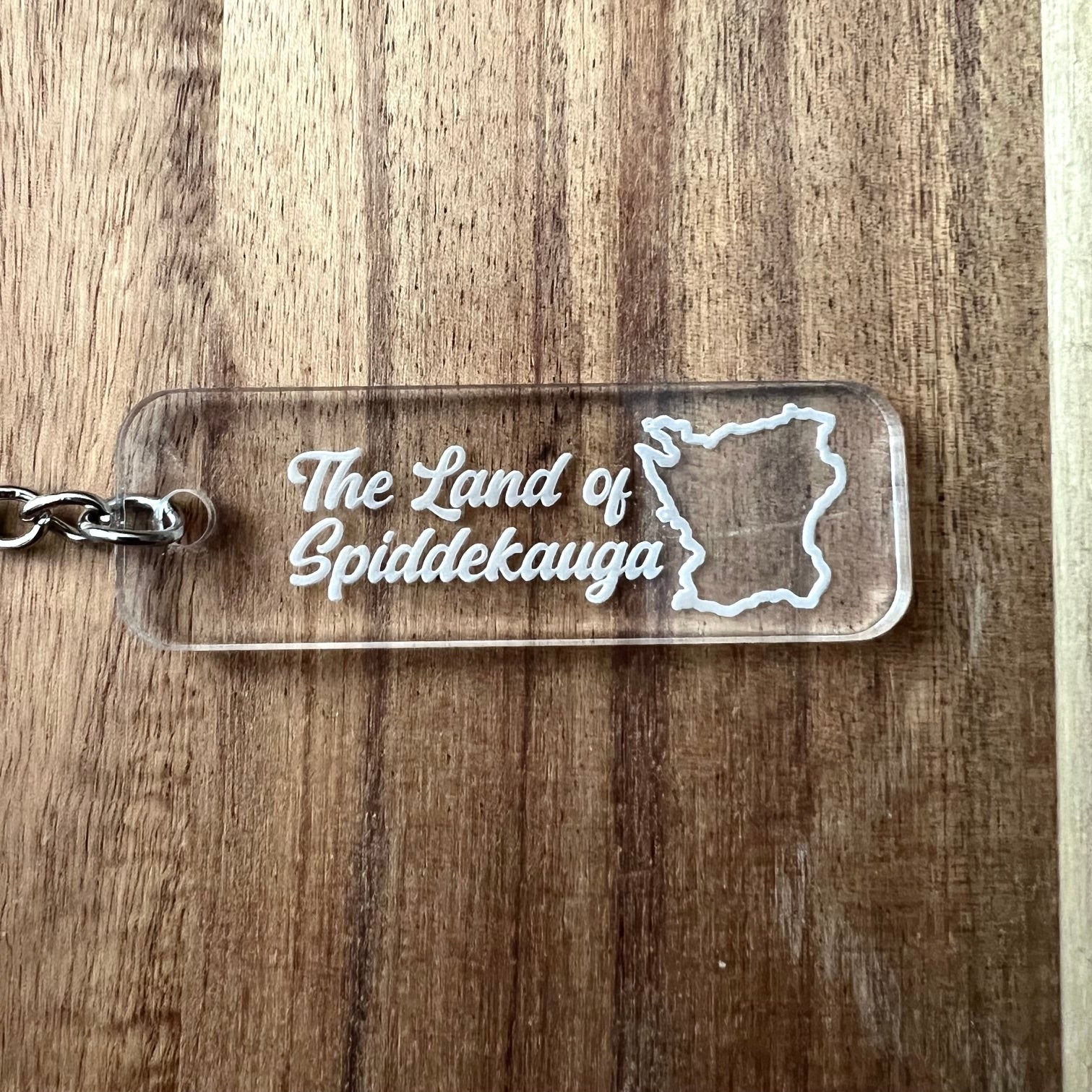 Nyssa Skåne keyring featuring a detailed design of the land of Spiddekauga on a metal keychain.