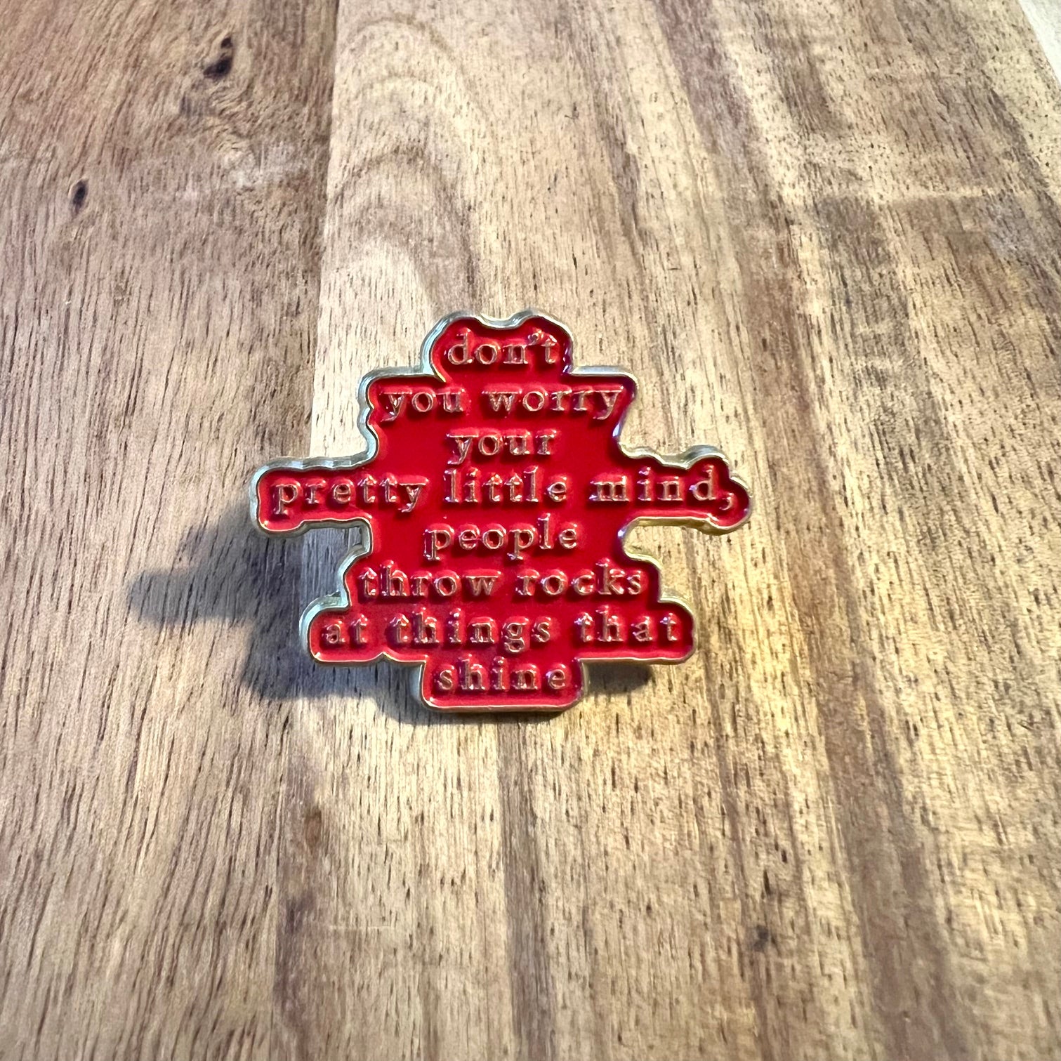 Nyssa "Don't You Worry" enamel pin featuring a colorful design, shown on a white background.