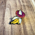 Nyssa BananaDonut pin featuring a colorful banana and donut design on a metal pin backing.