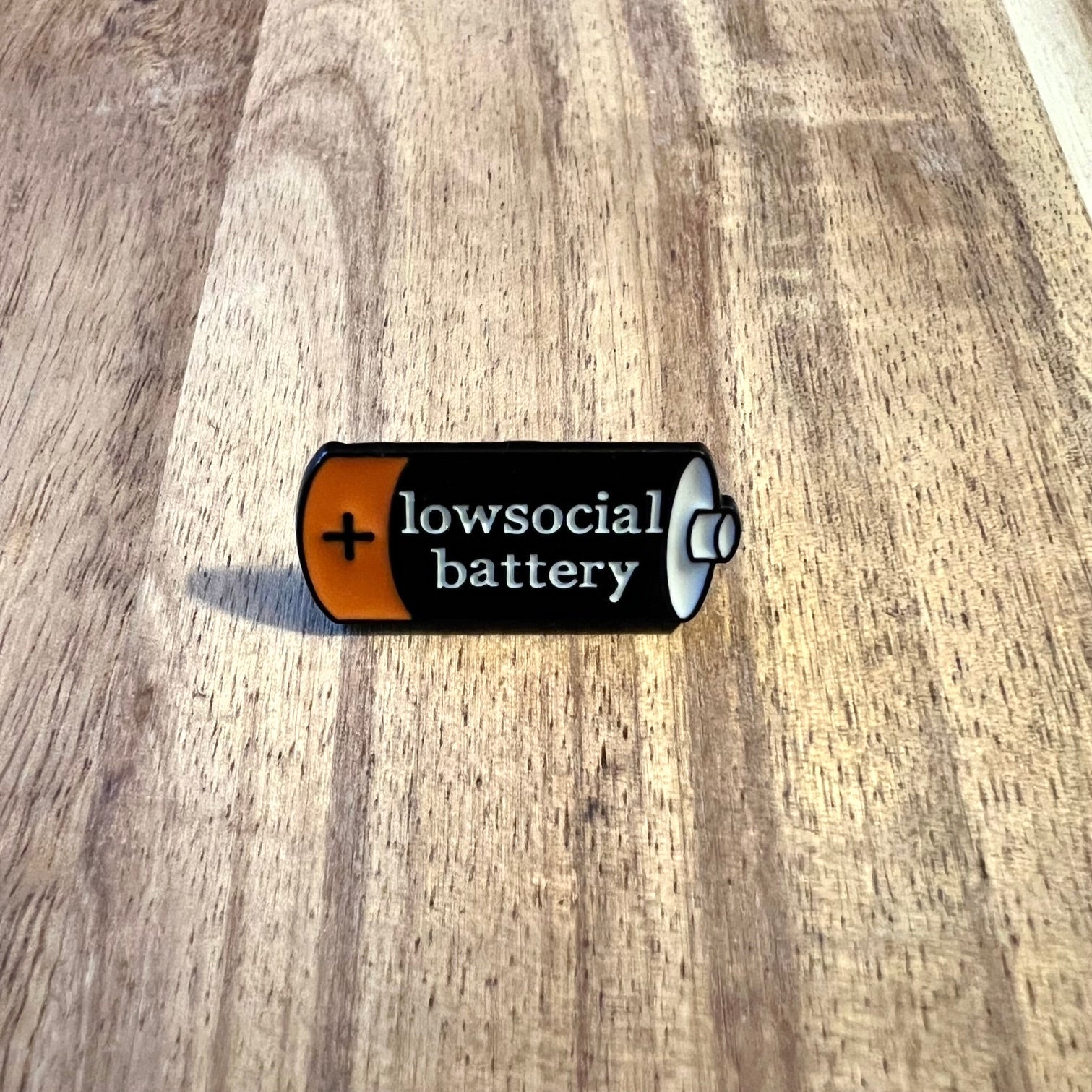 Nyssa Lowsocial Battery pin featuring a small, detailed metal pin with a battery design on a white background.