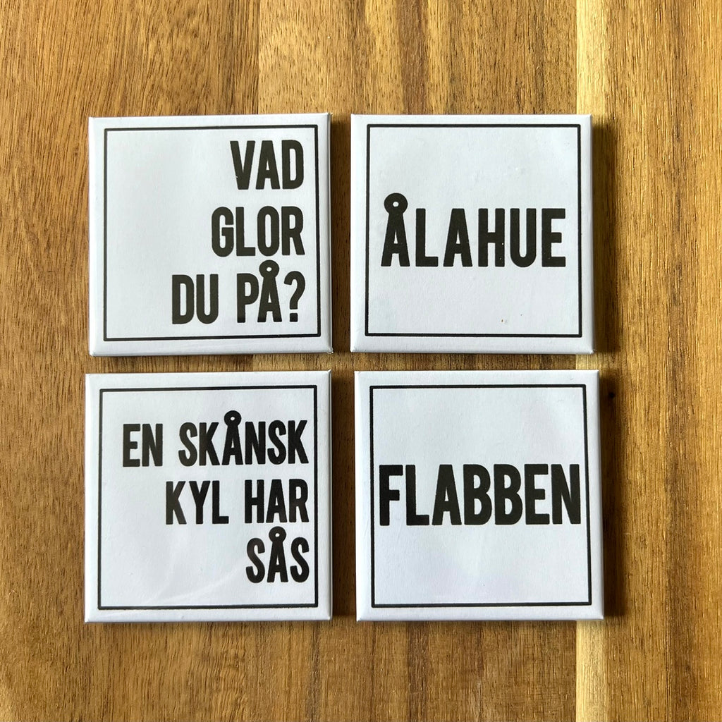 Set of four Nyssa Flabben refrigerator magnets with colorful, playful designs displayed on a kitchen fridge.