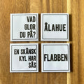 Set of four Nyssa Flabben refrigerator magnets with colorful, playful designs displayed on a kitchen fridge.