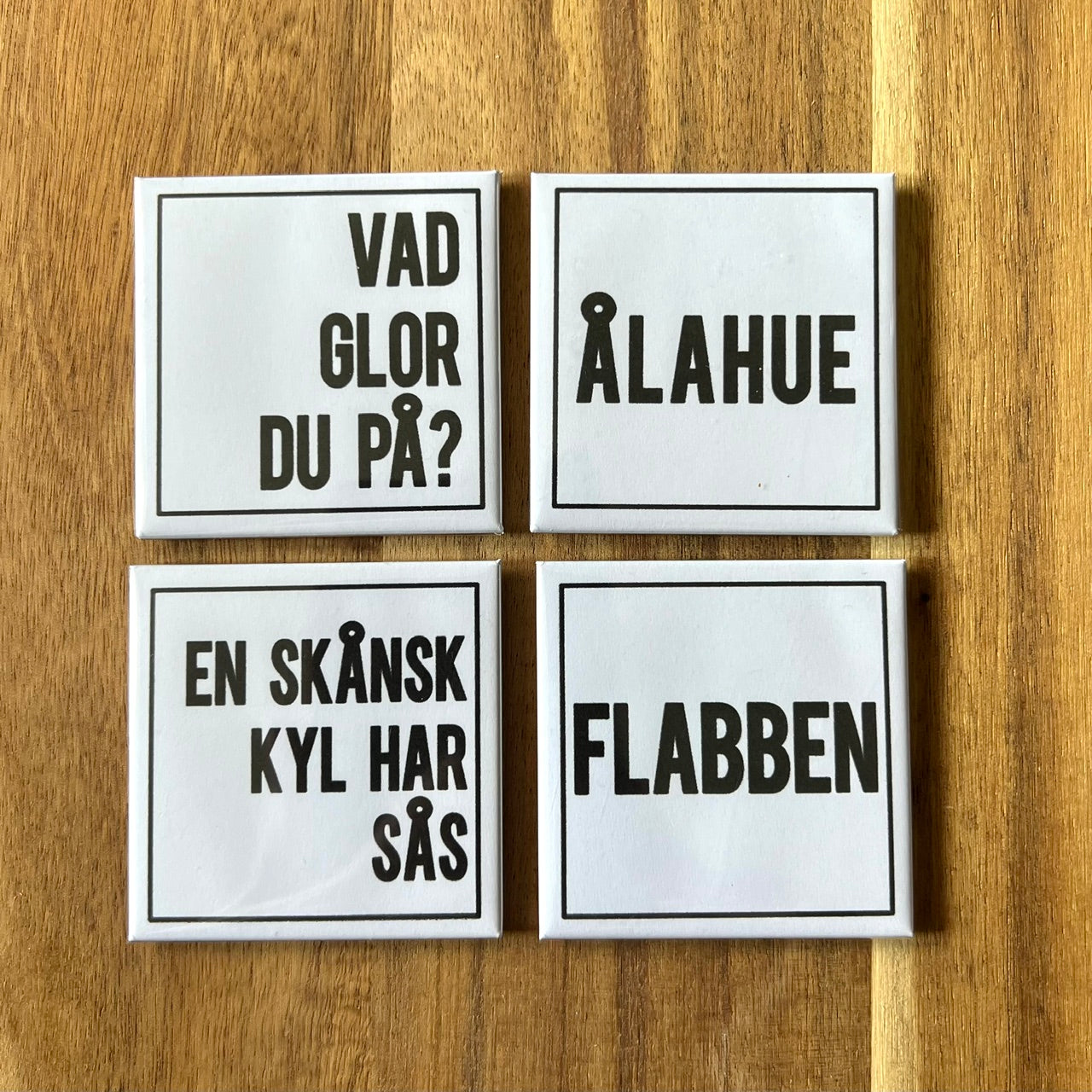 Set of four Nyssa Flabben refrigerator magnets with colorful, playful designs displayed on a kitchen fridge.