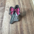 Nyssa cute but psycho pin featuring a playful, colorful design with a cartoon character on a metal pin back.