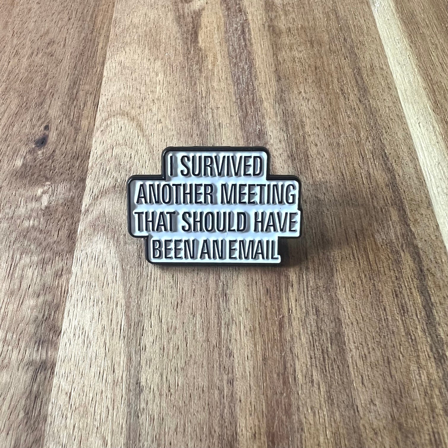 Nyssa "I Survived" pin featuring a metal safety pin design with bold lettering, perfect for clothing or accessories.